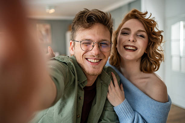 istock Happy couple taking a selfie at home, winking and smiling 2235018222