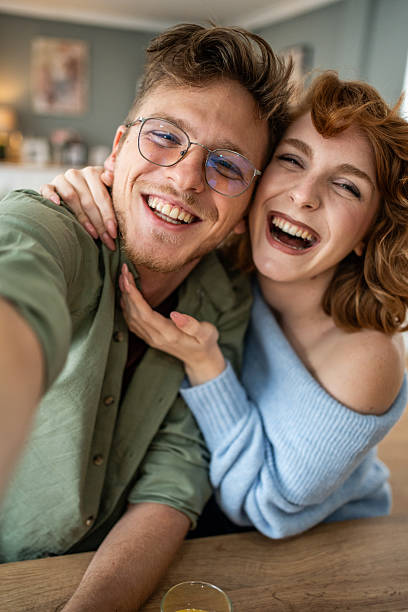 istock Cheerful couple taking a selfie and having fun at home 2235018387