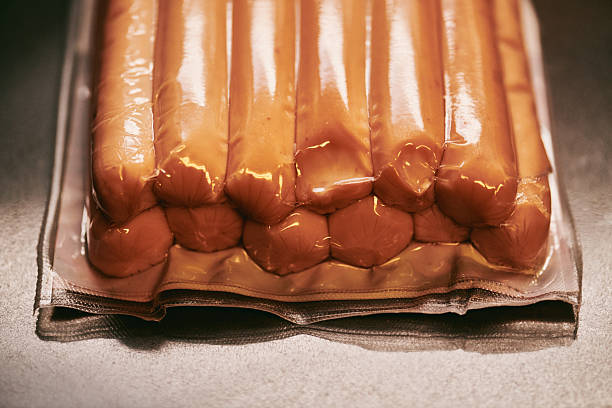 A neatly arranged pack of fresh sausages vacuum-sealed in clear plastic, highlighting freshness and preserving quality. Ideal for cooking or food storage.
