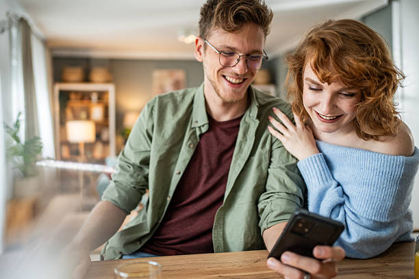 istock Happy couple sharing a special moment on smartphone at home 2235018552
