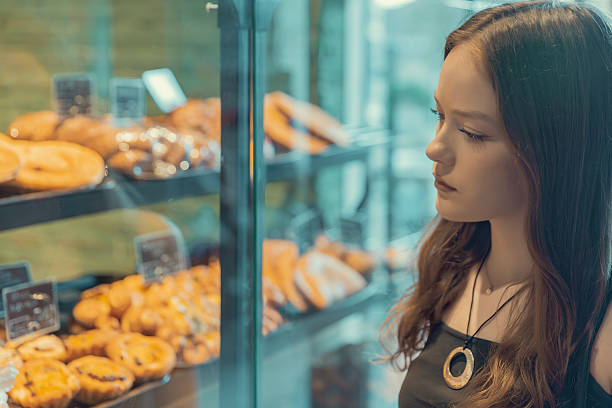istock Young woman choosing pastries in a bakery display 2235019771