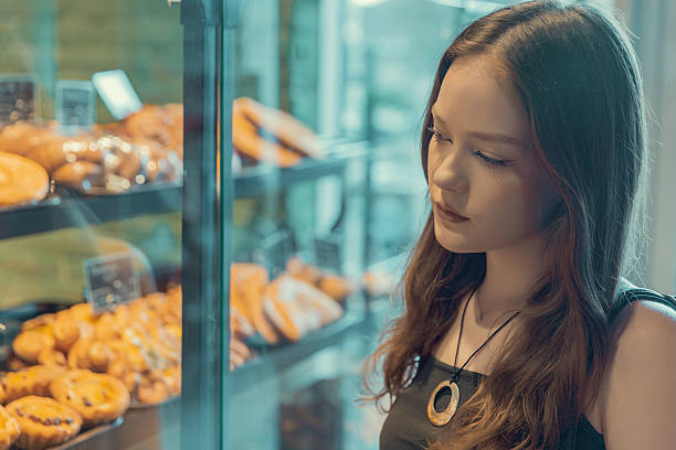 istock Young woman choosing pastries in a bakery display 2235019776