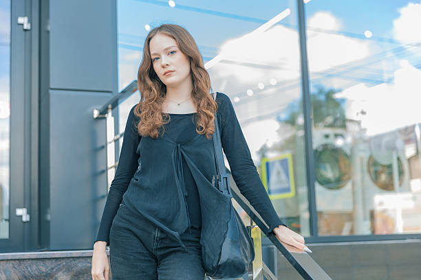 istock Young woman standing in front of a laundromat looking at camera 2235020270