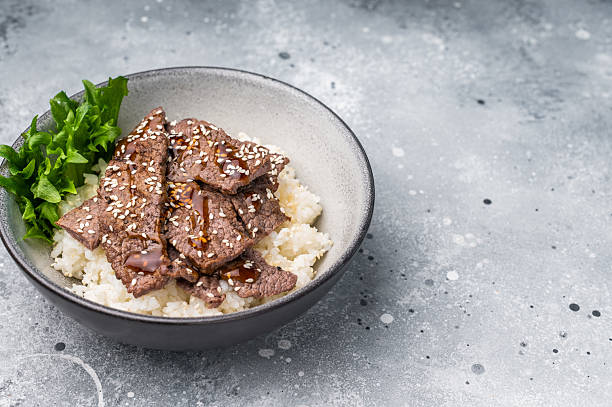 Delectable yakiniku feast, featuring a variety of marbled beef cuts and rice. A culinary journey that captures the essence of Japanese grilling traditions. grey background. top view