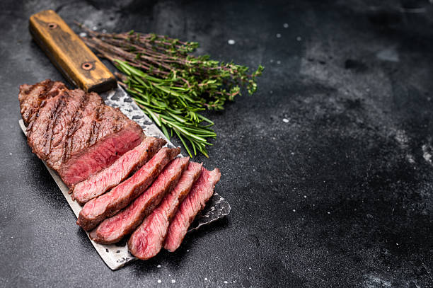 istock Savory shoulder steak Denver, beautifully cooked on the grill, highlighting its marbled texture and succulent taste. black background. top view 2235021862