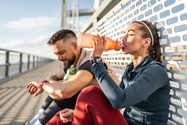 istock Athletes resting and drinking water after training on bridge 2235021927