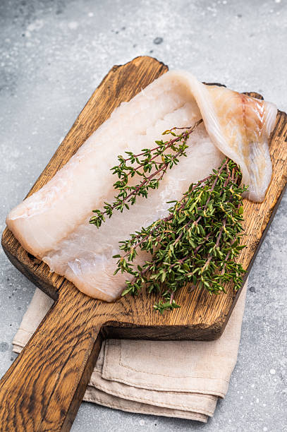 istock Fresh cod fish fillet, showcasing its delicate texture and pristine color, perfect for grilling or baking. grey background. top view 2235022752