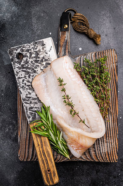 istock Freshly cut cod fish fillet, highlighting its mild taste and versatility in various dishes. black background. top view 2235022918