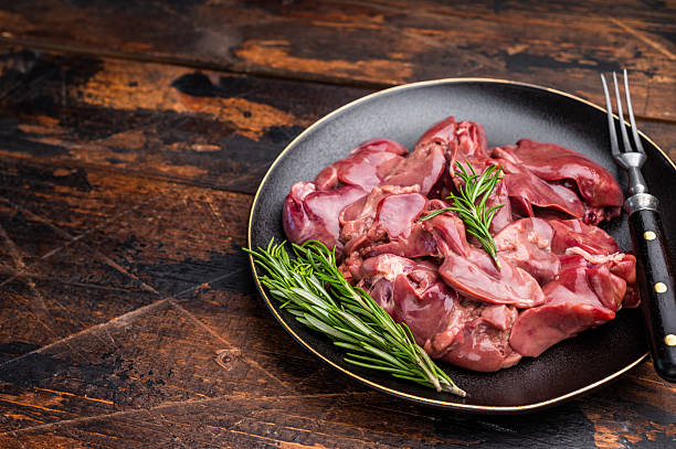 istock Raw chicken liver, featuring a glossy sheen and rich hue. A versatile ingredient that brings bold flavors to any culinary creation. wooden background. top view 2235023593