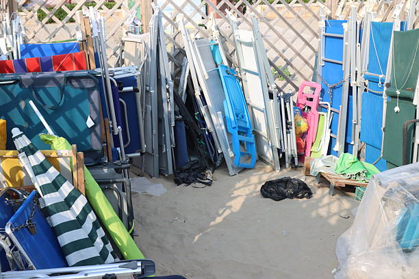 istock Stacked beach chairs and umbrellas creating colorful mess on sandy beach 2235023614