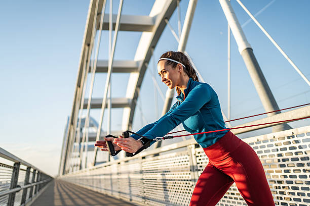 Young sportswoman training outdoors with a resistance band