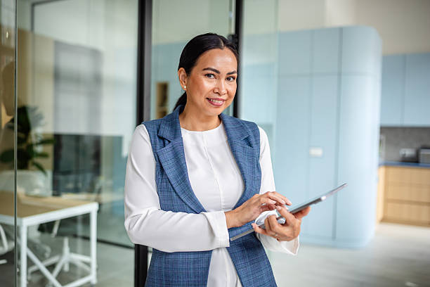 istock Professional Asian woman confidently working in a modern office setting with a tablet 2235027402
