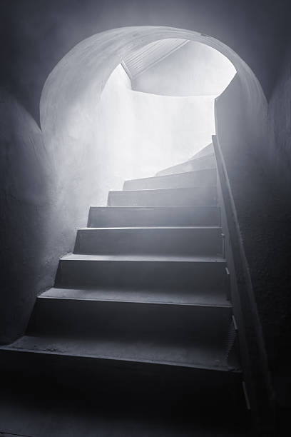 istock Stairway leading to a mysterious bright light in a dark room 2235031399
