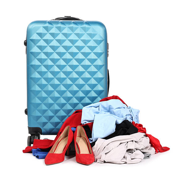 istock Suitcase and messy pile of clothes isolated on white 2235034145