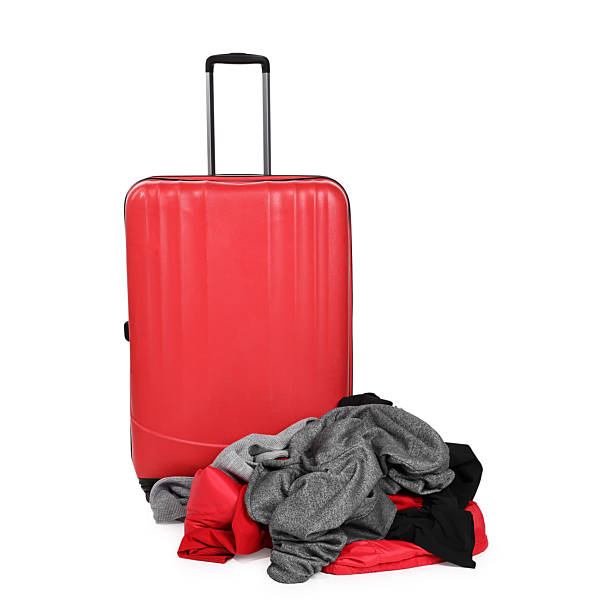 istock Suitcase and messy pile of clothes isolated on white 2235034272