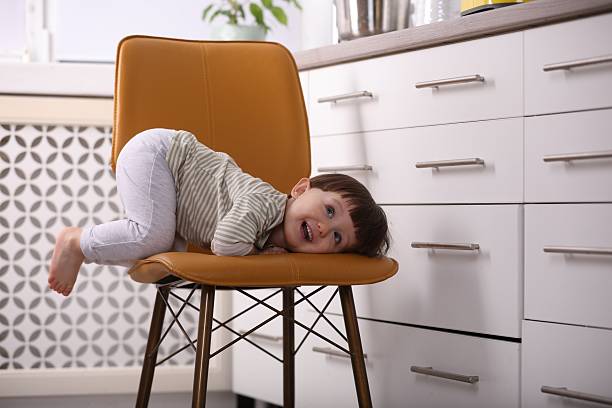 Kid's table and chair with a star pillow in a white, empty room interior with a dollhouse in the background. Place your product