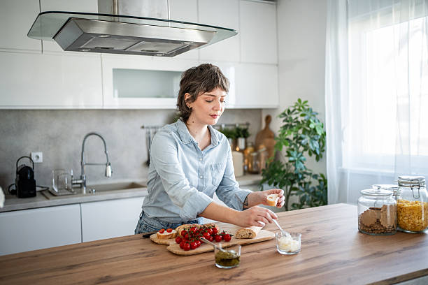 istock Young woman preparing bruschetta in modern kitchen 2235036029