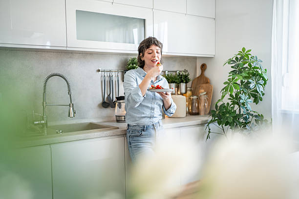 istock Young woman enjoying a healthy breakfast in her modern kitchen 2235036139