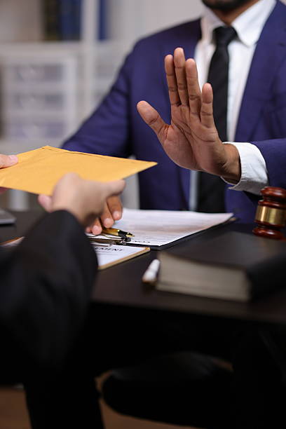 istock Honest officials refuse bribes. Lawyer refusing a bribe from a businessman in his office, he is pushing back the envelope with his hand. 2235036996