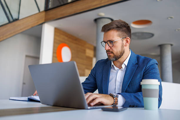 istock Focused businessman working on laptop in modern office 2235038044