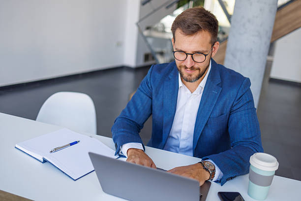 istock Businessman working on laptop in modern office 2235038324
