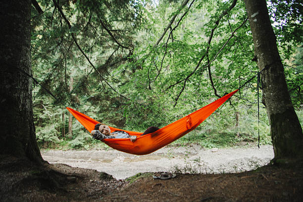 istock Serene Woman Relaxing in a Hammock by a Peaceful Riverside Forest 2235043001
