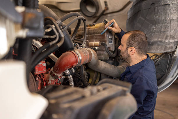 istock Male Mechanic Inspecting Truck Engine in a Professional Workshop Setting 2235045447