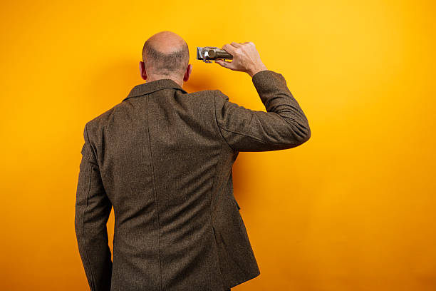 Man holding hair clipper, back view