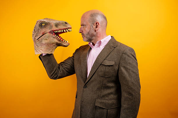 istock Man in suit holding dinosaur head 2235048739