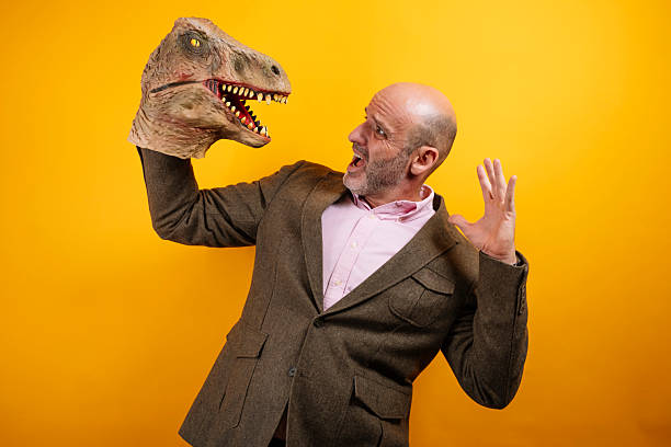 istock Man in suit holding dinosaur head 2235048742