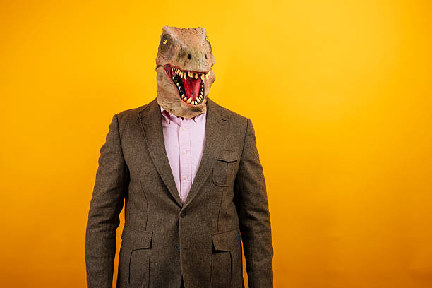 istock Dinosaur masked man standing formally in suit 2235048754