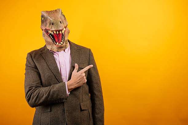 istock Dinosaur masked man standing formally in suit 2235048762