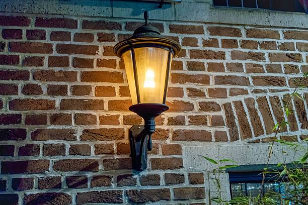 istock Vintage lantern illuminating brick wall at night 2235049994