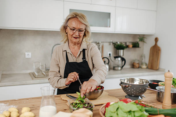 istock Senior woman preparing a fresh salad in a modern kitchen 2235050706
