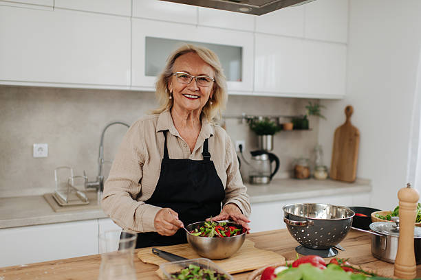 istock Senior woman preparing healthy salad in modern kitchen 2235050708