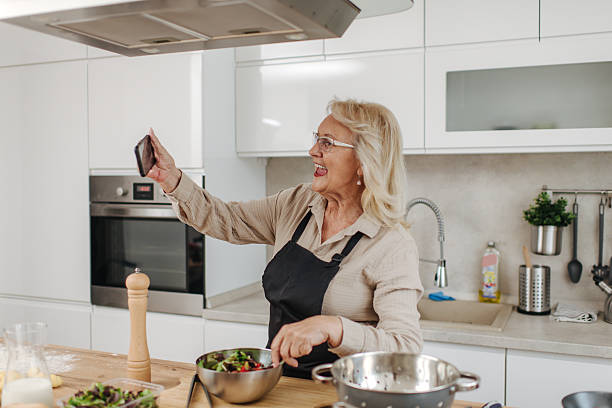 istock Senior woman making a video call while cooking in the kitchen 2235050788