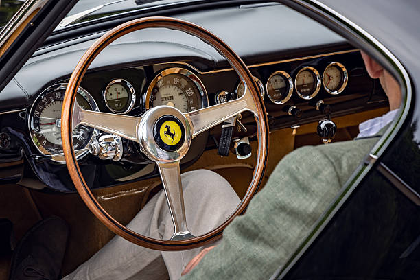 London, England - August 31, 2024: Man sitting and showing interior dashboard of 1962 Ferrari 250 GT Berlinetta SWB. Concours of Elegance 2024, Hampton Court Palace, London, UK