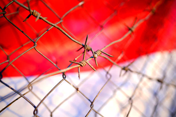 Barbed wire on Flag of Poland, background. Poland flag with Barbed wire, close-up. Barbed wire Poland flag border. Polish Flag with Barbed wire on border control at Ukraine, Belarus and Lithuania.