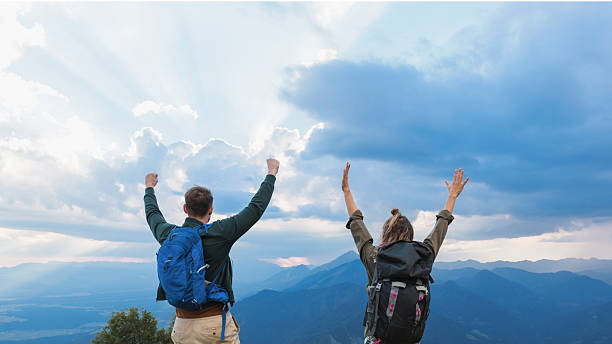 istock Couple celebrating success on mountain peak hike 2235062028