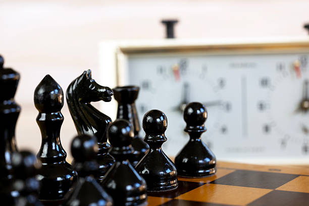 istock Chess pieces on a chessboard on the background of a chess clock 2235062040