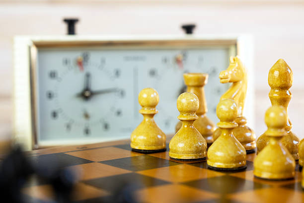 istock Chess pieces on a chessboard on the background of a chess clock 2235062637
