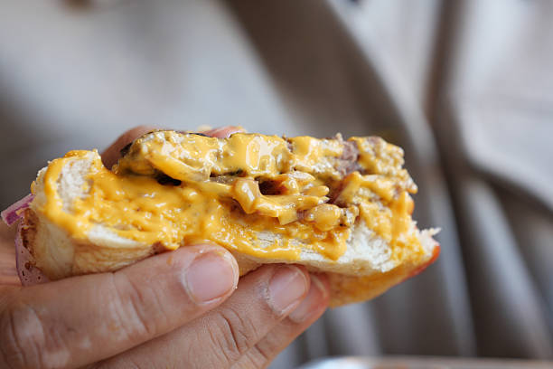 istock Delicious burger with melted cheese held by a hand 2235063412
