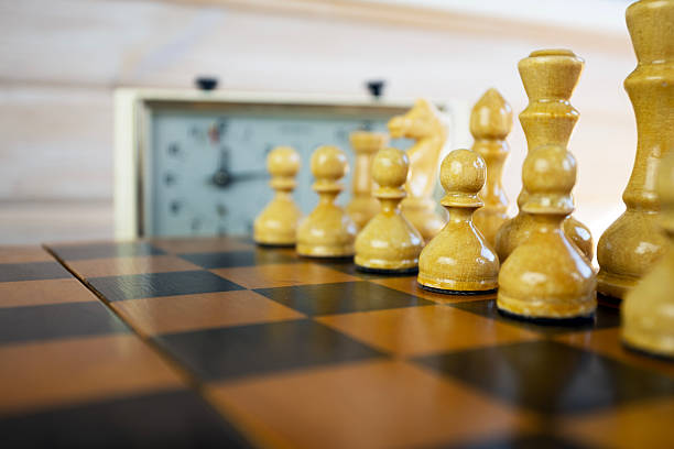 istock Chess pieces on a chessboard on the background of a chess clock 2235063556