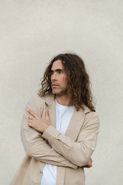 istock Thoughtful man with long Hair against beige wall. 2235068214
