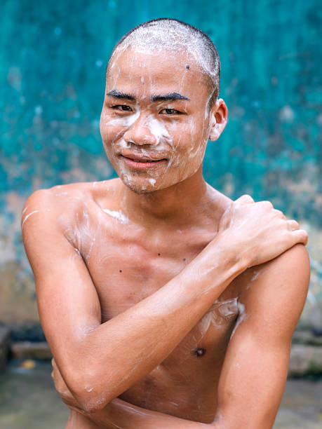 istock Young Buddhist monk at a monastery in Myanmar taking a shower filled with bath foam 2235070251