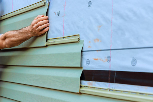 istock Worker installs green PVC siding on building during home renovation project 2235075062