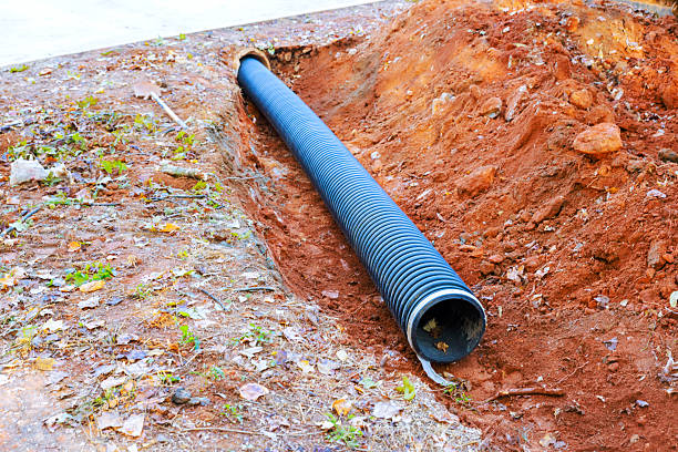 istock Underground drainage pipe placed in excavated area with soil debris during construction work 2235075142
