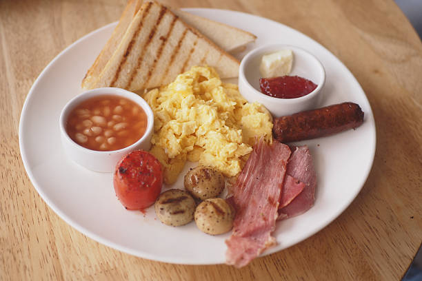 Enjoy a hearty breakfast featuring scrambled eggs, toast, and baked beans.