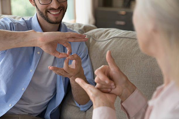 istock Closeup young man and aged woman communicating using hand gestures 2235092059