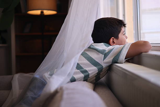 istock Happy teenage boy looking through a window 2235095392